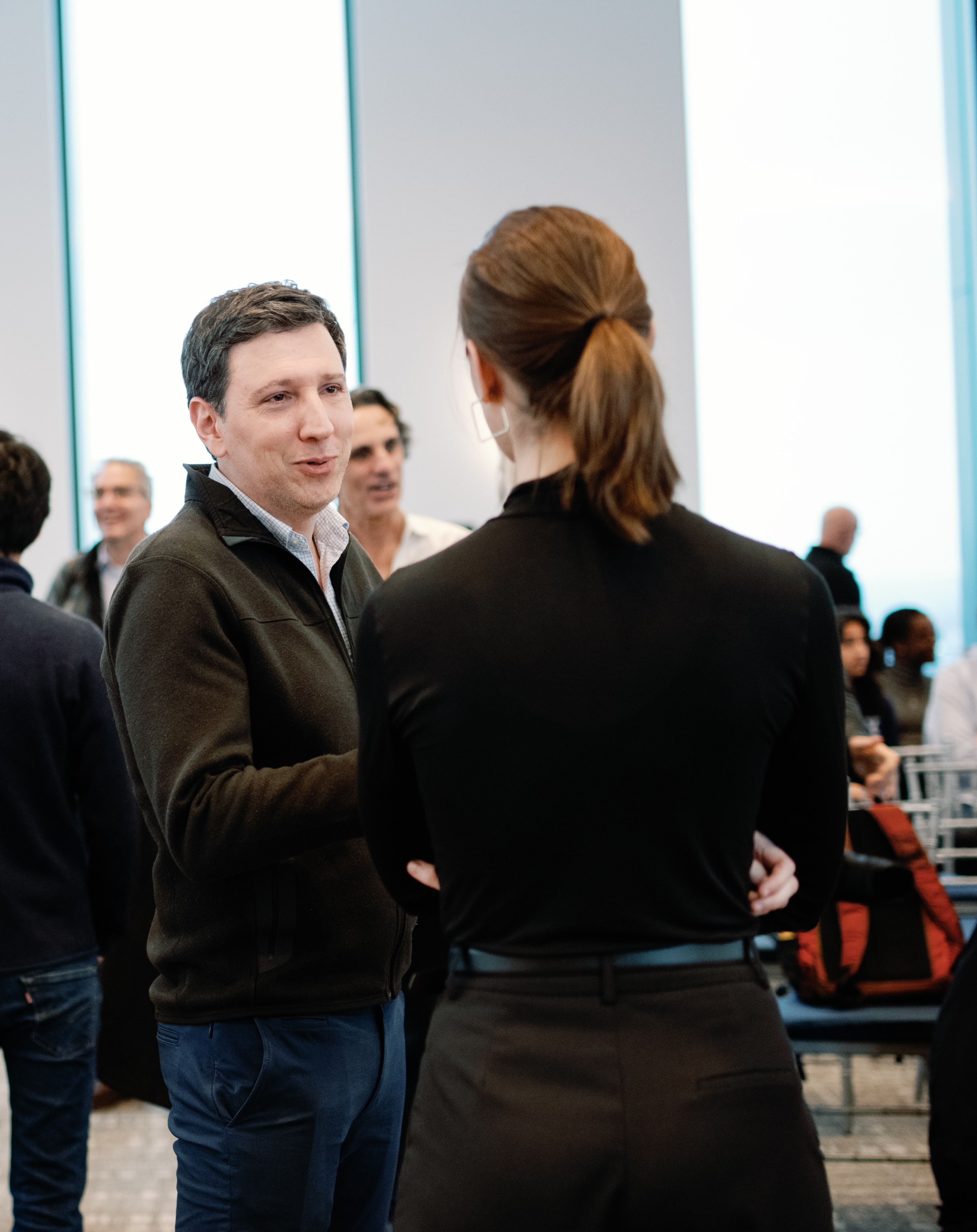 Guillermo Noguera speaking to a colleague at an event.