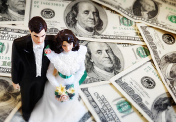 photo of wedding cake topper on top of a pile of money