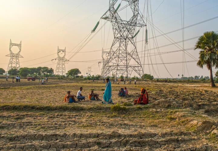 People sitting under power lines. 