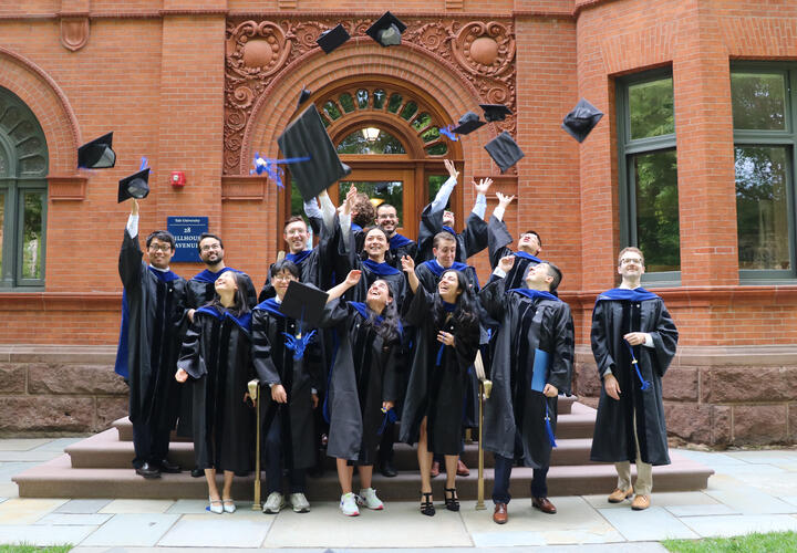 the Class of 2023 throwing their graduation caps in the air outside 28 Hillhouse Ave